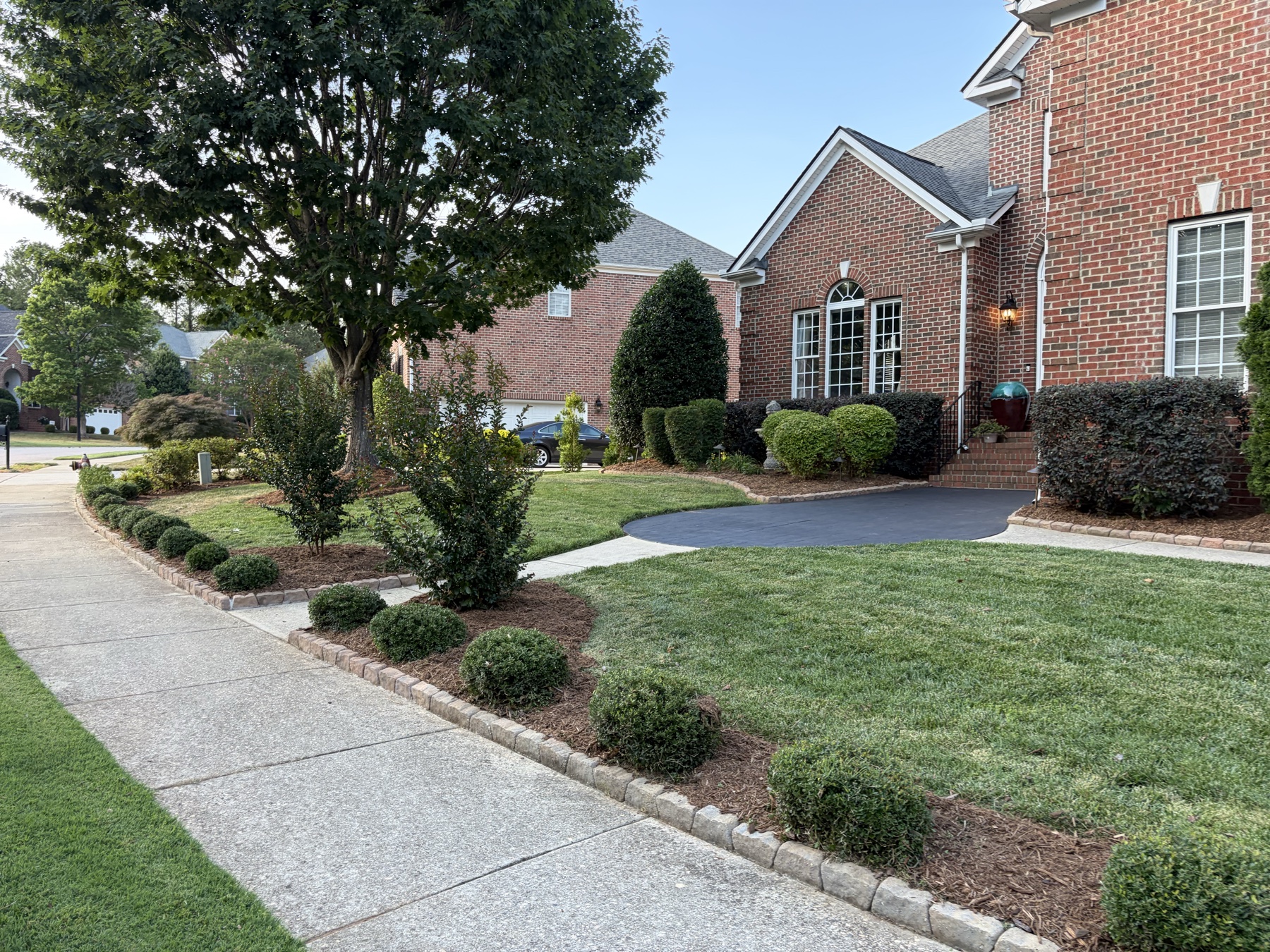 Finished Raleigh property with a maintained lawn, clean beds, and an open front walkway